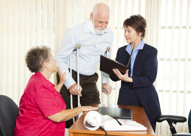 lderly man on crutches consulting with a female lawyer and a doctor or nurse in a professional office setting.